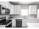 White kitchen with stainless steel appliances and subway tile backsplash at 6429 Flag Stop Dr, Whitestown, IN 46075
