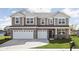 Two story home with gray siding and brick accents, two-car garage at 6429 Flag Stop Dr, Whitestown, IN 46075