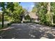 Asphalt basketball court with surrounding hedges and a home in the background at 6470 Around The Hills Rd, Indianapolis, IN 46226