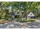 Tudor style home with black and white exterior, landscaping, and large trees at 6470 Around The Hills Rd, Indianapolis, IN 46226