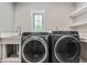 Functional laundry room with washer, dryer, and shelving at 6470 Around The Hills Rd, Indianapolis, IN 46226