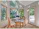 Sunlit breakfast nook with glass-top table and wicker chairs, access to patio at 6438 Pin Oak Dr, McCordsville, IN 46055