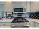 Modern kitchen with stainless steel appliances and dark blue backsplash at 6438 Pin Oak Dr, McCordsville, IN 46055