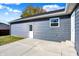 House exterior showcasing gray siding, white doors and a concrete patio at 7234 N Christopher Ln, Fairland, IN 46126