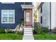 Front entry of a two-story navy house with red door at 1327 E 11Th St, Indianapolis, IN 46202