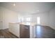 Open kitchen with white cabinets, island, and stainless steel dishwasher at 7920 Magnolia St, New Palestine, IN 46163