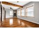 Spacious living room featuring hardwood floors, a stone fireplace, and large windows at 814 E 23Rd St, Indianapolis, IN 46205