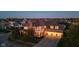 Brick house with 3-car garage, large yard, and mature trees. Evening lighting at 7189 Lockford N, Avon, IN 46123