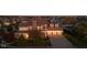 Brick house with 3-car garage, large yard, and mature trees. Evening lighting at 7189 Lockford N, Avon, IN 46123
