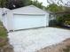 Detached single car garage with white overhead door and gravel driveway at 309 S Fleming St, Indianapolis, IN 46241
