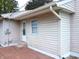 Rear view of a house with light beige vinyl siding, a brick patio, and gutters at 309 S Fleming St, Indianapolis, IN 46241