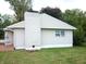 Side view of a house with light beige vinyl siding, a brick patio, and a chimney at 309 S Fleming St, Indianapolis, IN 46241