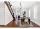 Bright dining room features hardwood floors, a charming wooden staircase, and an elegant chandelier at 1007 Broadway St, Indianapolis, IN 46202