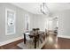 Bright dining room features hardwood floors, a charming wooden staircase, and an elegant chandelier at 1007 Broadway St, Indianapolis, IN 46202