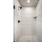 Clean shower with white vertical tile and hexagon floor tile at 456 Monon Way Dr, Carmel, IN 46032