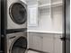 Modern laundry room with stacked washer and dryer and ample storage at 456 Monon Way Dr, Carmel, IN 46032