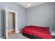 Bedroom with grey walls, red bedding, and access to another room at 1120 Lexington Ave, Indianapolis, IN 46203