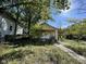 Yellow bungalow with front porch and mature trees at 3221 E 38Th St, Indianapolis, IN 46218