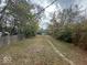 Long, narrow backyard with overgrown grass and a partially visible structure at 3221 E 38Th St, Indianapolis, IN 46218