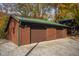 Three-car garage with brown siding and green metal roof at 9562 N Gasburg Rd, Mooresville, IN 46158