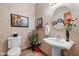 Elegant powder room with pedestal sink, decorative wallpaper, and framed art at 1079 Old Eagle Way, Greenwood, IN 46143