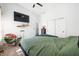 Serene bedroom featuring a green duvet, floating shelves, and a comfortable armchair at 318 N Tacoma Ave, Indianapolis, IN 46201
