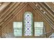 Attic space with stained glass window and wooden beams at 3708 State Ferry Rd, Solsberry, IN 47459