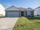 Brick house with gray garage door and landscaped lawn at 6105 Card Blvd, Indianapolis, IN 46221