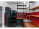 Small galley kitchen with butcher block countertops, black appliances, and industrial shelving at 108 E St Clair St # B, Indianapolis, IN 46204
