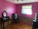 Bedroom with pink walls and wood flooring at 647 W Mcgregor Rd, Indianapolis, IN 46217