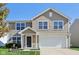 Two-story house with beige siding, white garage door and landscaping at 4633 Angelica Dr, Indianapolis, IN 46237