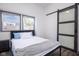 Bright bedroom with a comfy bed, gray carpet, and barn door at 2221 E Michigan St, Indianapolis, IN 46201