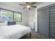 Simple bedroom with ceiling fan, dresser, and striped bedding at 2221 E Michigan St, Indianapolis, IN 46201