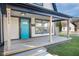 Inviting front porch with light-colored wood flooring and a teal door at 2221 E Michigan St, Indianapolis, IN 46201