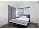 Cozy bedroom with a bed, gray closet doors, and two windows at 2221 E Michigan St, Indianapolis, IN 46201