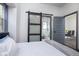 Bedroom with bed, barn door entry to bathroom and view into dining area at 2221 E Michigan St, Indianapolis, IN 46201