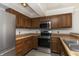 Galley kitchen with stainless steel appliances and wood cabinets at 8168 Shorewalk Dr # A, Indianapolis, IN 46236