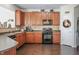 Kitchen with wood cabinets, black appliances, and hardwood floors at 3159 Hurst St, Whiteland, IN 46184