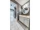 Bathroom with white vanity, tiled floor, and round mirror at 808 Copperfield Xing, Danville, IN 46122