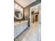 Bathroom with white vanity, tiled floor, and round mirror at 808 Copperfield Xing, Danville, IN 46122