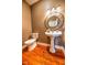 Elegant powder room features a pedestal sink, updated toilet, and wood flooring at 808 Copperfield Xing, Danville, IN 46122