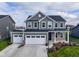 Two-story house, gray siding, white garage doors, landscaped yard at 16703 Ayshire Dr, Fishers, IN 46037