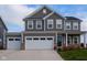 Two-story gray house with white garage doors and stone accents at 16703 Ayshire Dr, Fishers, IN 46037