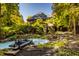 Landscaped backyard with a pond and wooden bridge at 9468 Sullivan Pl, Zionsville, IN 46077