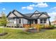 Craftsman style home with gray and white exterior, stone accents, and landscaping at 12594 Tidecrest Dr, Fishers, IN 46037