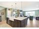 Modern kitchen with an expansive island, stainless steel appliances, and a farmhouse sink at 12594 Tidecrest Dr, Fishers, IN 46037
