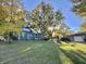 Spacious backyard with large trees, detached garage, and play structures at 74 Morgan St, Danville, IN 46122