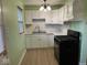 Charming kitchen with white cabinets, light green walls, and modern appliances at 6150 Oak Ave, Indianapolis, IN 46219