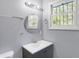 Updated bathroom features a vanity, round mirror, and window at 3616 N College Ave, Indianapolis, IN 46205