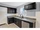 Modern kitchen with dark cabinets, granite countertops, and stainless steel dishwasher at 3616 N College Ave, Indianapolis, IN 46205